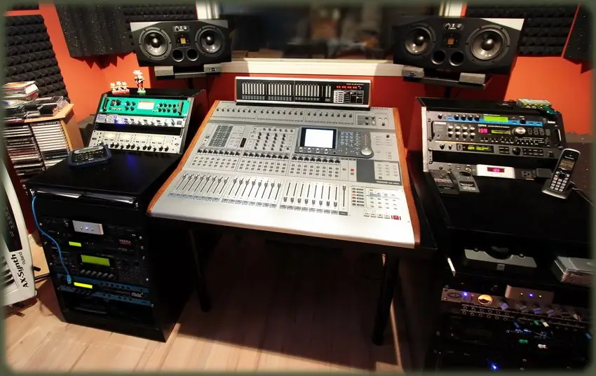 La régie du Studio Héri-Son : console Tascam DM-4800, moniteurs Adam A77X, baies de rack, murs orange et mousse acoustique